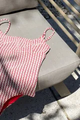 Traje de baño enterizo negro con escote en U, tiras finas y espalda redondeada. Sin almohadillas.