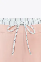 Pantalón de tiro alto color crema, con cintura combinada a contraste tipo boxer con cordones ajustables. Detalle de pinzas en delantero, bolsillos laterales y falso bolsillo de vivo en espalda.