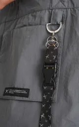 Bolso tipo tote bag color gris, confeccionado en microfibra técnica de secado rápido. Cuenta con un compartimento principal con elástico ajustable, un bolsillo interno con cierre y un bolsillo externo con velcro.