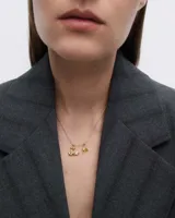 Dije charm dorado con forma de dos cisnes formando un corazón y una circonita blanca engarzada.