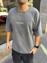 Remera gris de algodón pesado con efecto lavado. Estampa en la espalda con texto "Introducing STWD Records 00 000 P&B 0091 EST 0 9 Entertainment Co. Superior Sound Quality Bhe Dig".