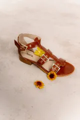 Sandalias bajas de cuero color marrón con múltiples tiras y hebillas metálicas ajustables.