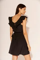 Vestido corto negro con escote redondo y volados en los hombros.