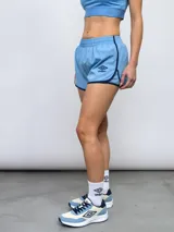 Short de entrenamiento color celeste con detalles en azul marino en los bordes y el logo de Umbro. Tiene cintura elástica y un corte deportivo.