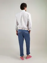 Camisa celeste a rayas verticales de lino, corte regular fit, cuello italiano, cierre con botones, manga larga terminada en puño simple y logo bordado en el pecho.