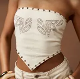 Top strapless color crudo, con diseño bordado y tachas metálicas.