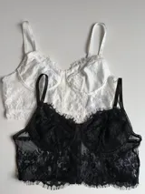 Corset negro de encaje con copas con aros y breteles finos regulables.