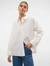 Camisa blanca oversize de manga larga con cuello clásico, puños abotonados y cierre frontal de botones.