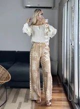 Pantalón palazzo blanco con estampado de motivos tribales en negro, cintura elástica y bolsillos laterales. Talle único.