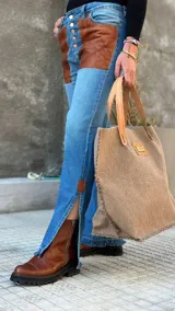 Pantalón de jean celeste con cintura elastizada, corte recto, bolsillos laterales y aplique de cuero marrón en el bolsillo delantero. Presenta botones metálicos en los laterales de la cintura y etiqueta de cuero en la parte trasera.