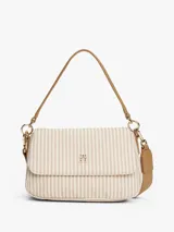 Cartera de hombro Tommy Hilfiger con rayas verticales beige y blancas, logo dorado en el frente, correa de mano marrón y correa bandolera ancha color beige.