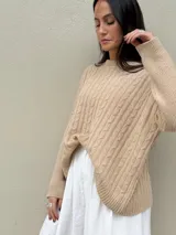 Sweater color crema de punto con trenzas.