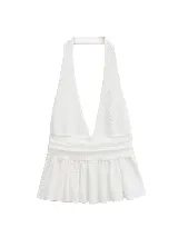 Top blanco con escote halter, espalda descubierta y volado en el ruedo.