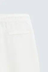 Pantalón verde oscuro de algodón con textura, corte recto, cintura elástica ajustable con cordón, bolsillos laterales y traseros de vivo.