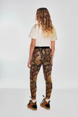 Pantalón babucha con estampado de piel de serpiente en tonos marrones y negros.