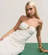 Vestido midi blanco sin breteles, confeccionado en bengalina. Presenta adornos en el busto y recorte cutout en la cintura.