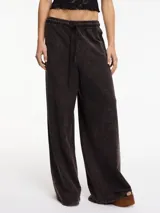 Pantalón negro de tiro alto y pierna recta, con pretina elástica y lazos ajustables.