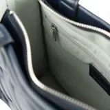 Bolso tote azul marino con diseño acolchado en símil cuero, doble asa corta y correa larga regulable.