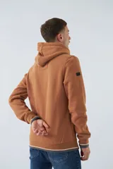 Buzo canguro color marrón con capucha ajustable, bolsillo canguro, fit regular, arte estampado en relieve y logo en goma.