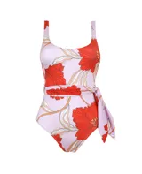 Traje de baño enterizo con estampado de flores rojas y hojas color crema sobre fondo lila. Presenta corte alto en la pierna y cinturón lila con lazada lateral.