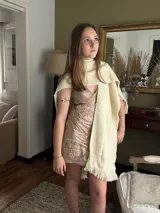 Vestido corto de lentejuelas color verde oliva, con escote en V, breteles finos cruzados en la espalda, cut-outs laterales y volado en el ruedo.