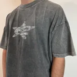 Remera gris con efecto gastado, corte boxy y estampado trasero con logo de la marca Edgy en blanco.
