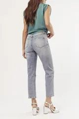 Pantalón de jean celeste de corte mom, con tachas plateadas.