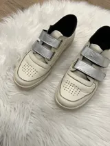 Zapatilla de cuero con cierre tipo velcro, diseño cómodo para uso diario.