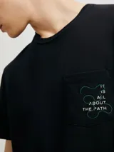 Camiseta beige de corte regular con bolsillo en el pecho y bordado con texto en azul.