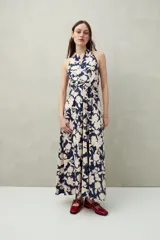 Vestido largo de algodón liviano con estampado floral en tonos azul y blanco, escote halter y lazo que se anuda al cuello.