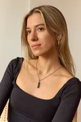 Collar dorado con cadena fina y dije colgante en forma de lágrima de piedra natural azul con vetas blancas.