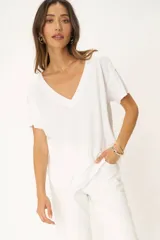 Camiseta blanca de cuello en V, con hombros caídos, dobladillo curvo y ajuste holgado.