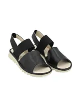 Sandalias bajas color dorado con dos tiras anchas, una sobre los dedos y otra elástica en el talón.