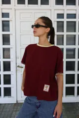 Remera de algodón color azul marino, corte relajado con hombro caído. Presenta cuello redondo blanco y bordado a mano en contraste en los puños de las mangas. Tiene un parche bordado en la parte inferior del frente.