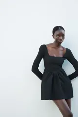 Vestido corto negro de manga larga con escote cuadrado y textura en relieve.