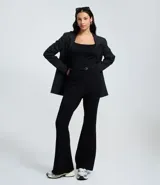 Pantalón negro de tiro alto, corte flare (acampanado) y tejido estructurado. Incluye un cinturón fino negro.