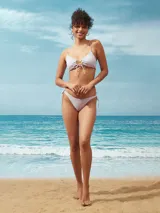 Conjunto de bikini lila con corpiño triangular con lazo ajustable en el centro y bombacha con tiras laterales.
