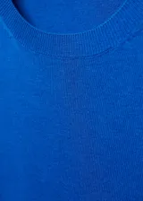 Jersey de punto fino color crema, con diseño recto, cuello redondo y manga larga.