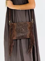 Bandolera marrón de cuero con solapa con textura símil cocodrilo y flecos.