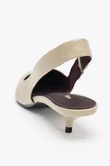 Zapato destalonado color beige con tira trasera elástica ajustable, punta fina y tacón kitten.