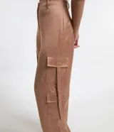 Pantalón wide leg de textura acetinada color café, con bolsillos cargo con solapa en los laterales y tira con moña en los bolsillos y en la barra. Cintura con trabillas y cierre por botón y cremallera.