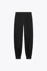 Pantalón de tiro medio confeccionado en hilatura con mezcla de viscosa, color negro. Presenta bolsillos laterales ocultos en costura, bajo acabado en puño con botones y cierre frontal con cremallera, botón y ganchos metálicos.