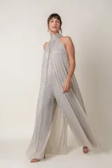 Mono plateado brillante de lurex, con cuello halter y corte palazzo.