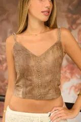 Top de cuero color marrón con escote en V y tirantes finos trenzados. Cuenta con un detalle vertical de pasamanería artesanal bordada a mano en el frente y cierre con broches en la espalda.