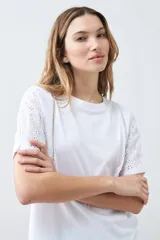 Remera roja de algodón con cuello redondo y mangas cortas con detalle de broderie. Corte clásico.