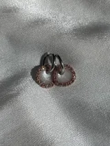 Aros plateados tipo argolla con dije circular con borde de strass color cobre y centro blanco brillante.