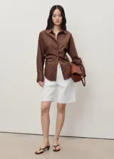 Short blanco de tiro medio con cierre de cremallera y botón, cinco bolsillos, diseño recto y bajo deshilachado.