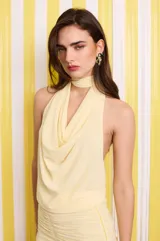 Top amarillo de microtul, con cuello halter y corte fluido en el pecho.