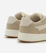 Championes casuales color beige, confeccionados en poliuretano con cordones y recortes.