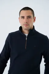 Buzo de hombre azul marino con medio cierre, cuello alto y logo estampado en el pecho. Corte regular y mangas largas.